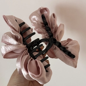 Detail view of pink satin cloud bubble pleated fabric hair claw clip with bow design