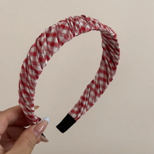 Nahaufnahme des rot-blau karierten Stoffstirnbands mit weicher Falten-Baumwolltextur
