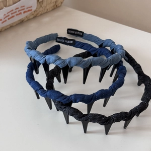 Détail d'un serre-tête tressé en jean avec dents antidérapantes et étiquette