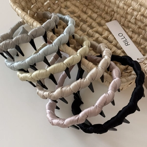 Detail view of satin fabric wrapped wavy hair hoops in six elegant low-saturation colors