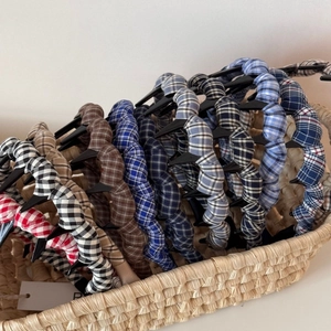 Elegant plaid woven wavy headbands in diverse colors displayed in a rustic basket