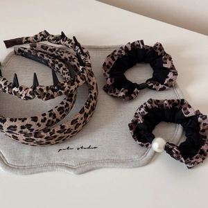 Détail d'un ensemble de serre-têtes léopard avec bandes en tissu et chouchou en perles