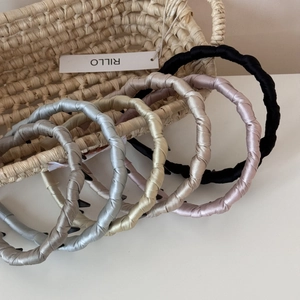 Macro detail of satin twisted headband showing silky fabric texture and inner non-slip teeth