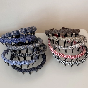 Detailed view of checkered fabric headbands with teeth in various classic plaid colors