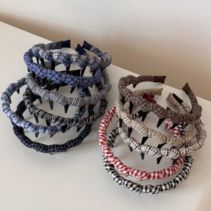 Detail of plaid fabric headbands showing non-slip inner teeth and wavy fold design