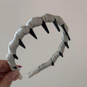 Detail view of the twisted satin fabric texture and non-slip inner teeth of the headband