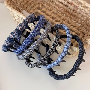 Detail of plaid fabric headbands with non-slip teeth in navy blue and grey patterns