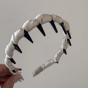 Detail of beige satin wrapped headband with black wide-toothed comb for secure styling
