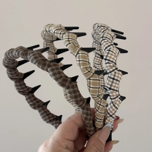 Detail of plaid fabric headbands with integrated small clips for styling loose hair