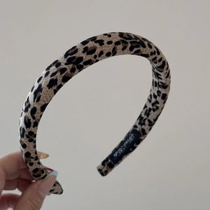 Détail du serre-tête épais avec imprimé léopard et étiquette tissée à l'intérieur