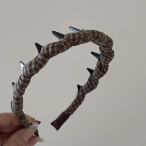Detail of coffee plaid fabric headband with black wavy hair comb for daily styling