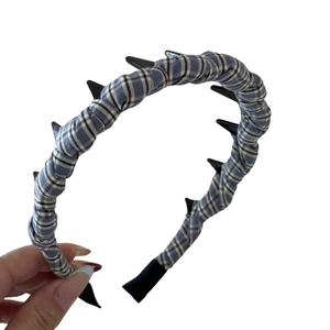 Plaid fabric headband with black spikes and wavy teeth for a stylish punk look