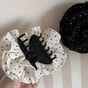 Detail of elegant polka dot fabric hair claw clip with pleated texture and firm grip