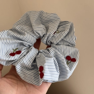 Détail du chouchou à rayures bleues avec des broderies de cerises rouges élégantes