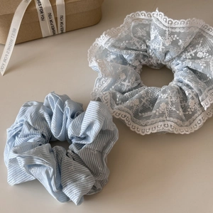 Dettaglio di elastici azzurri con pizzo floreale e raffinati motivi ricamati a righe fini