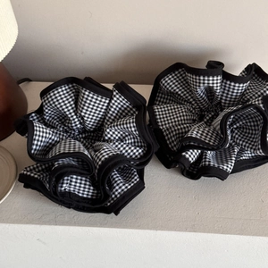 Detailed macro view of large oversized black and white gingham scrunchie with ruffled edges