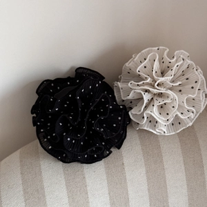 Detailed close-up of large pleated polka dot chiffon hair scrunchies on fabric background