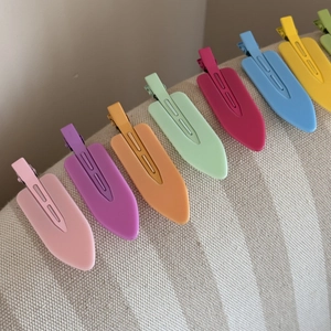 Macro shot of colorful seamless duckbill hair clips in various matte candy-colored finishes