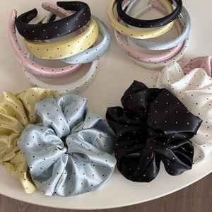 Close-up of polka dot satin headband and scrunchie set in assorted pastel colors
