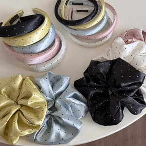 Close-up of vintage polka dot headbands and satin scrunchies in assorted soft colors