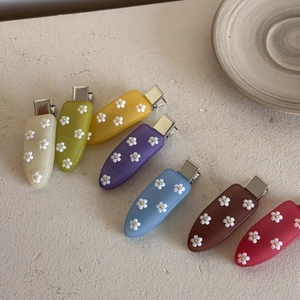 Ensemble détaillé de sept barrettes à fleurs colorées en acrylique sur pierre naturelle