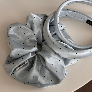 Close-up of light blue satin headband set with vintage black polka dot patterns