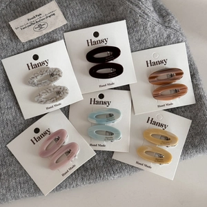 Set of six oval acetate hair clips in assorted colors on a white display card