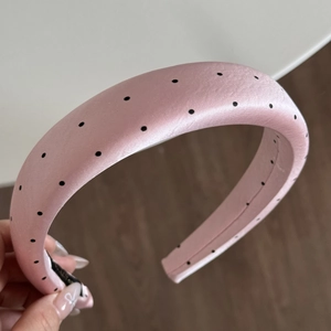 Close-up of pink polka dot headband made of premium satin with sponge padding