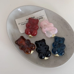 5-teiliges Set bunte Bären-Haarspangen mit goldenen Entenschnabel-Clips auf Keramiktablett