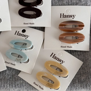 Set of four pairs of oval acetate hair clips in coffee, amber, blue, and cream colors