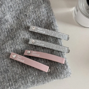 Detailed set of four hair clips with pink and silver glitter finishes and heart rhinestones