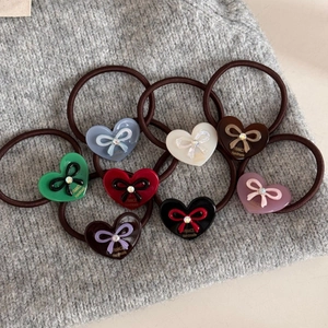 Détail du lot de 8 chouchous cœurs en acrylique avec nœuds sur fond en maille douce