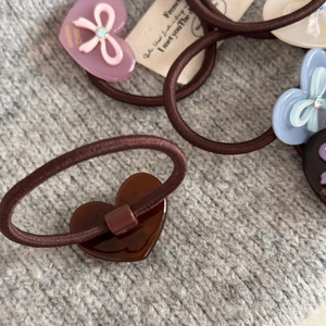 Détail d'élastiques à cheveux avec breloques cœur et nœud, gravés France Handmade