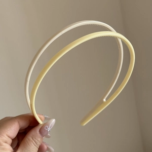 Close-up of non-slip inner teeth detail on candy-colored plastic headbands in cream and yellow