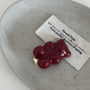 Nahaufnahme einer roten Bären-Haarspange mit glänzender Harzstruktur auf einem Teller