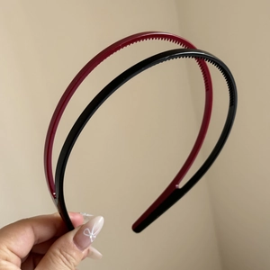 Detail view of black and dark red headbands with anti-slip teeth for secure hairstyling