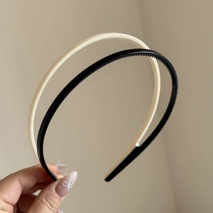 Close-up of black and beige nonslip hair hoops with inner teeth for a secure grip