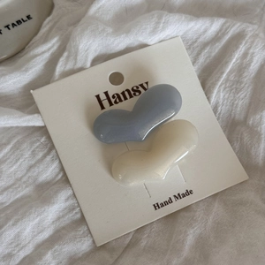 Close-up of heart-shaped pearl hair clips in blue and white on a display card