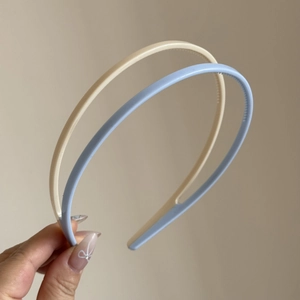Close-up of minimalist slim headbands with non-slip teeth in beige and light blue