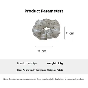 Detail view of white mesh scrunchie with black dots, 21cm diameter and 9.1g weight