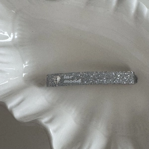 Detail of silver glitter hair clip with heart rhinestone and lar mood artistic lettering