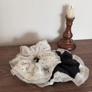 Elegant polka dot and solid black double-layer pleated scrunchies on a vintage wood surface