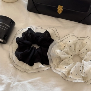 Detail of double-layer polka dot and pleated organza hair scrunchies set in black and white
