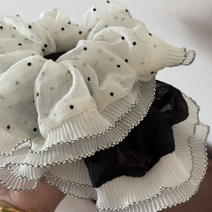 Detail view of layered polka dot chiffon hair scrunchie with pleated edges and soft texture