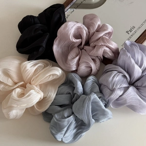 Detailed close-up of five satin scrunchies in elegant Morandi colors with silky texture