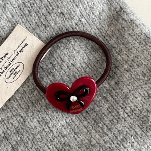 Détail d'un élastique coeur rouge avec nœud noir et lettrage doré fait main