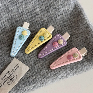 Cute triangular matte resin hair clips in pastel colors with smiley button details