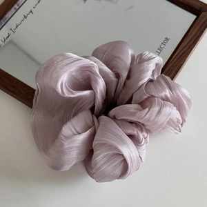 Detail of lavender oversized satin scrunchie with fine pleated texture and silky sheen