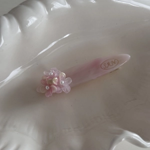 Détails d'une pince à cheveux à fleurs roses en résine avec perles et marbrures