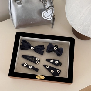 Vue détaillée des barrettes en denim et épingles à fleurs blanches dans un lot de 6